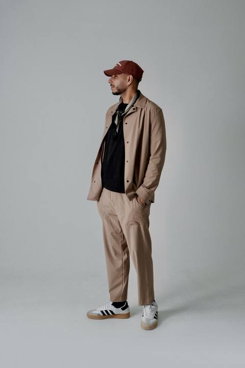 Nass Belabbas en studio, veste et pantalon beige, casquette bordeaux
